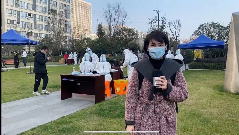 新聞廣播記者吳巧在核酸檢測現(xiàn)場做報道.jpg