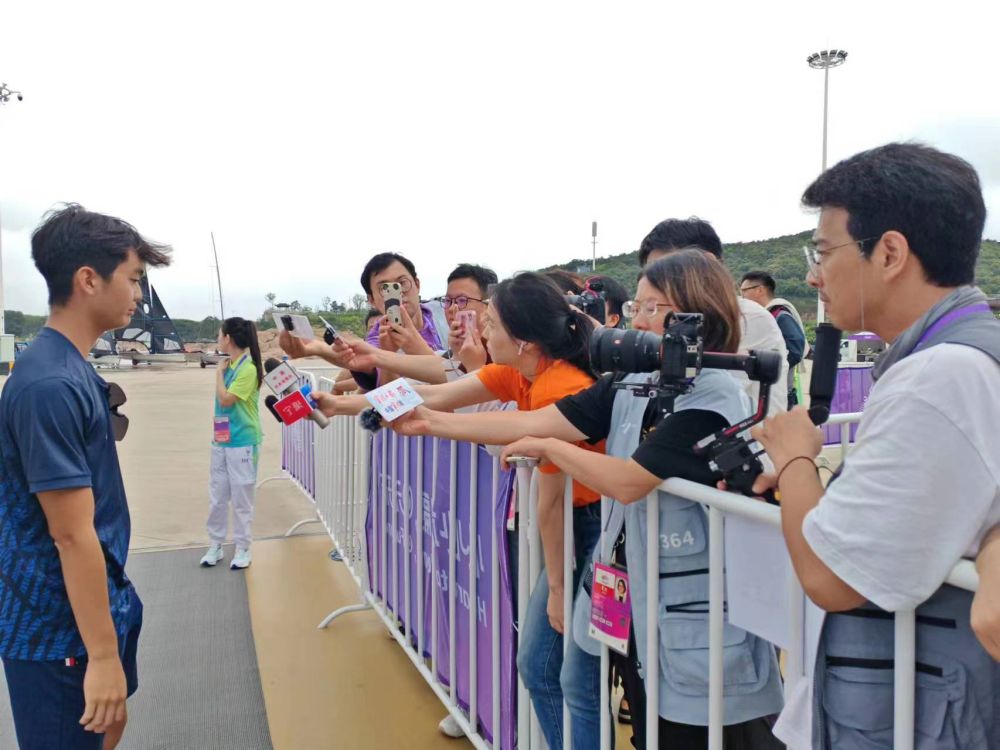 記者在帆船比賽混合采訪區(qū)采訪運動員（手長者勝）.jpg